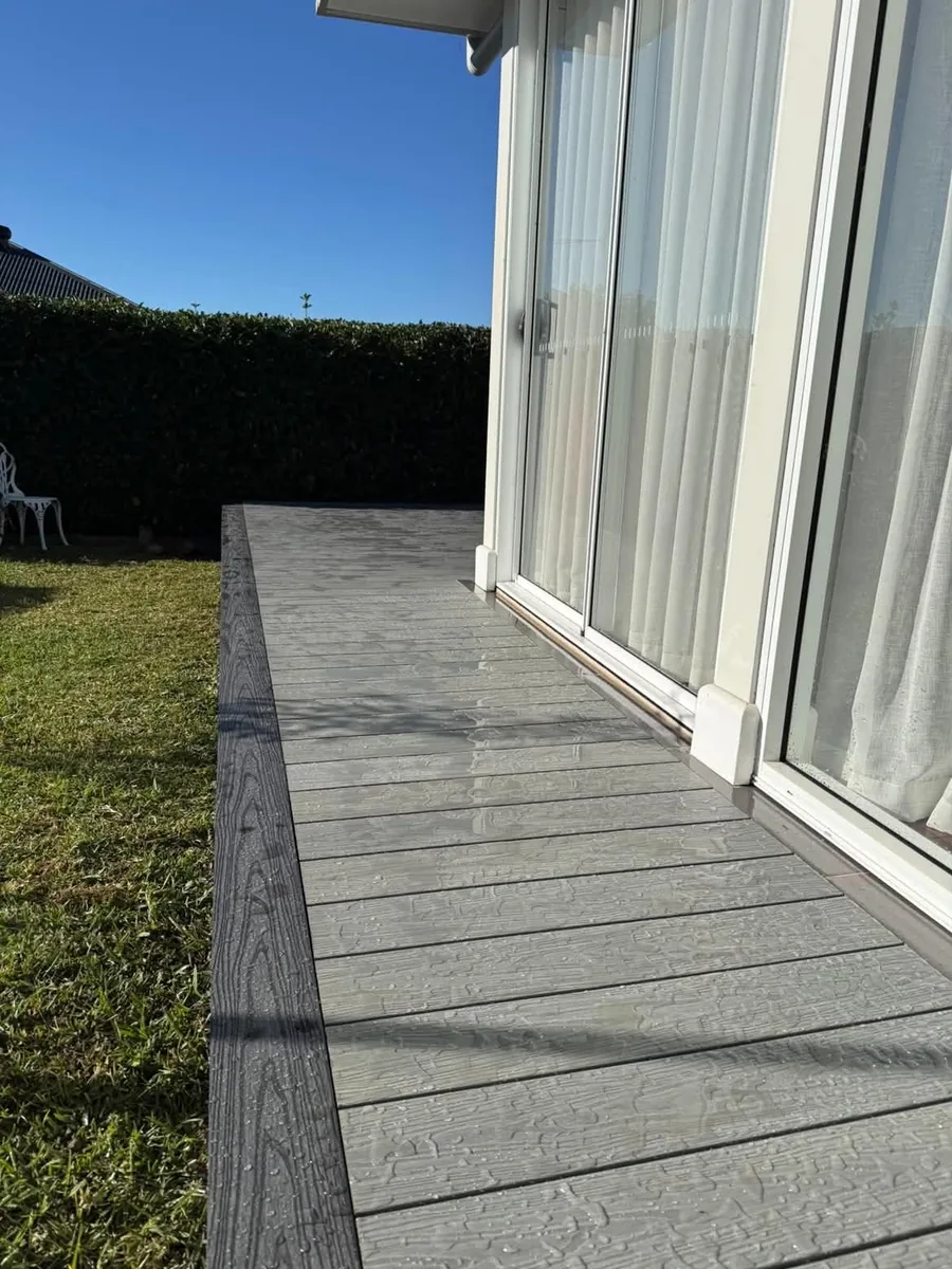 Close-up of grey composite decking boards beside a sliding door